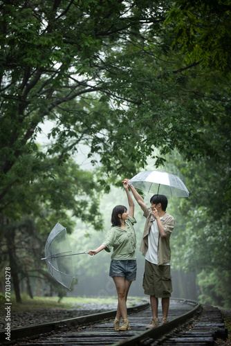 Young couple holding umbrellas