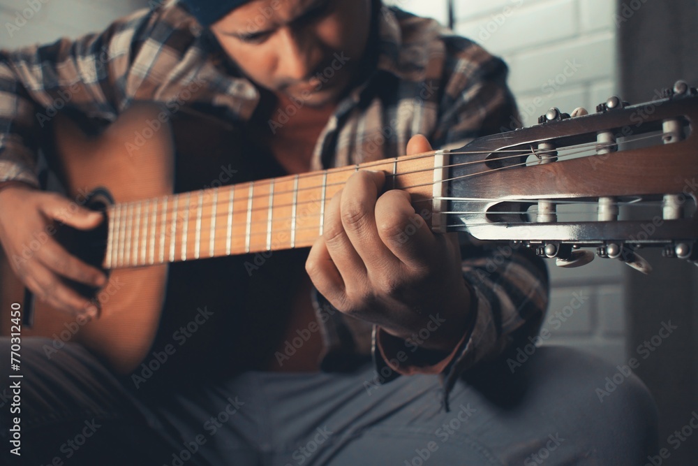 Obraz premium latin man practicing acoustic guitar
