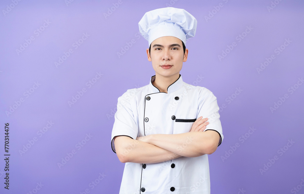 Young Asian male chef on background Young Asian male chef on background