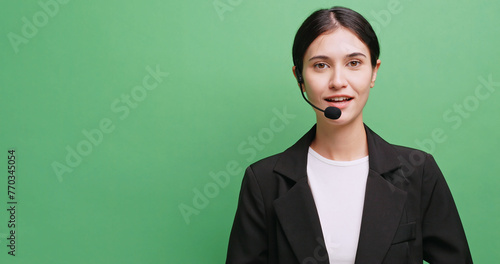 Young female economist explaining something. Isolated on green background in studio.