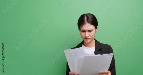 Young businesswoman stressed about work not achieving her goals. Isolated on green background in studio.