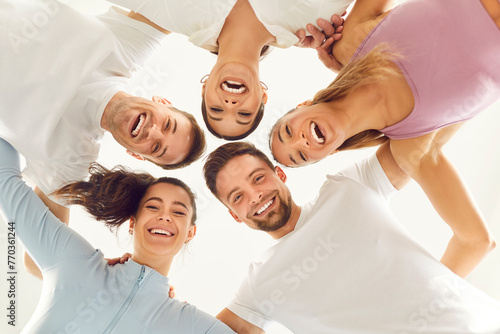 Bottom view portrait of a joyful smiling people friends students looking down into camera. Happy men and women standing in a circle and smiling at the camera on a white background.