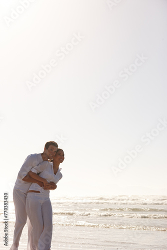 Happy couple, hug and beach with romance for love, embrace or valentines day in outdoor nature. Man and woman enjoying holiday, weekend or getaway together by the ocean coast or sea on mockup space © peopleimages.com