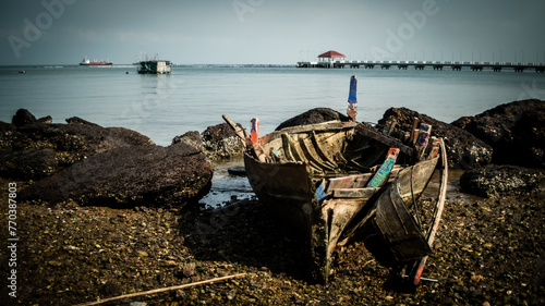 The wreckage of a local fishing boat is stuck in the rocks on the coast of the Gulf of Thailand.