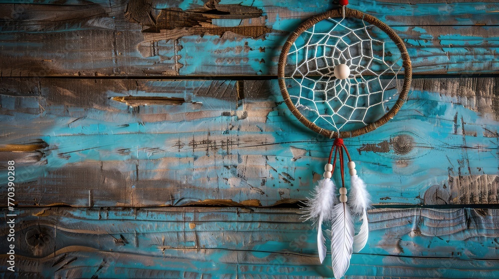 Dreamcatcher home decor white color on the wood background. Native American art, Olive dream catcher on aquamarine textured background. Texture of concrete, copy space for text
