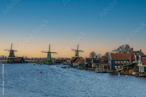 Zaandijk, the Netherlands. 15 March 2024. Zaanse Schans windmills. Panorama of traditional dutch houses, monumental wooden buildings at the Zaan river in Zaandijk photo