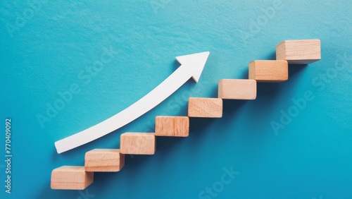 A minimalist design of wooden blocks stacked to form a step staircase, with a white arrow pointing upwards on a blue background. Symbolizes the continuous striving for achievement and progress.