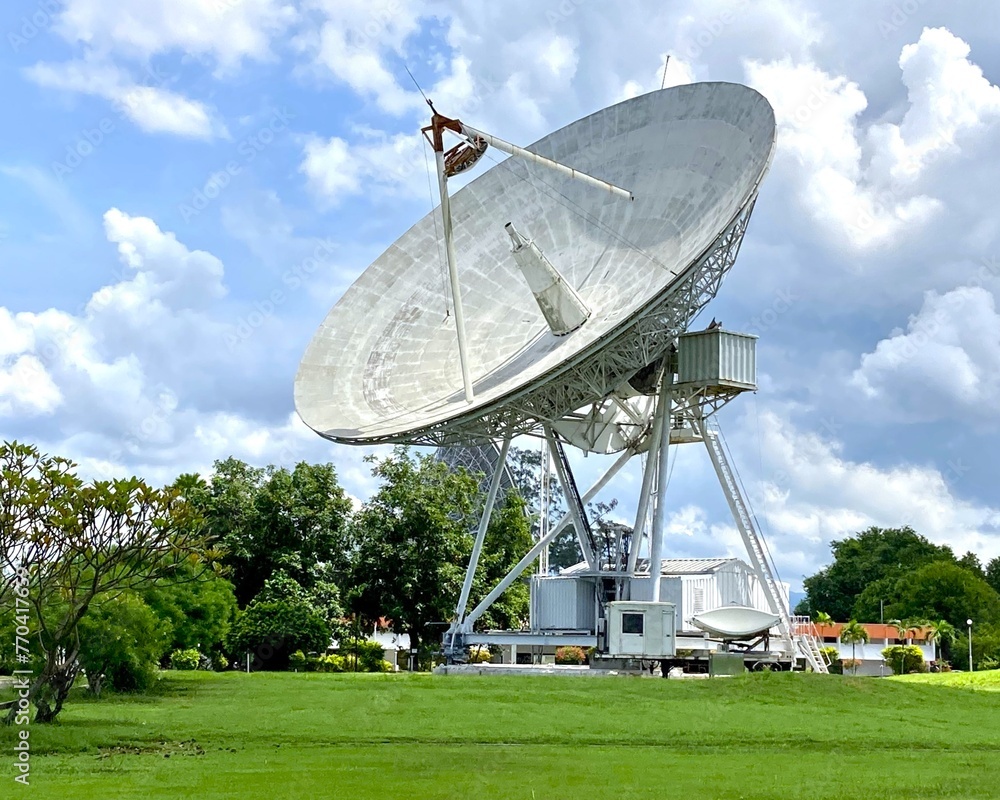 Large satellite dish and station with cloudy sky for telecommunications and broadcasting in Thailand