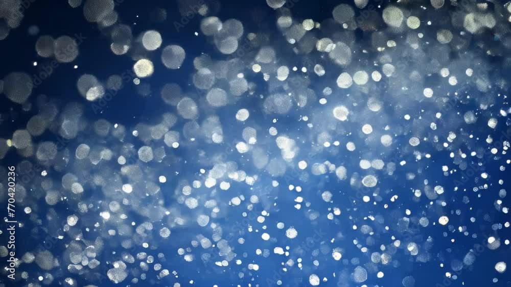 Glowing blue and white spherical bokeh dots scattered across an abstract background. The blurred orbs of light overlap, appearing to float amidst deep shades of blue. Glowing blue and white spherical bokeh dots scattered across an abstract background. The blurred orbs of light overlap, appearing to float amidst deep shades of blue.