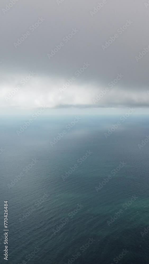 Aerial vertical view. Dramatic moody and gloomy rain clouds over sea. Abstract aerial nature summer ocean sunset sea and sky. Horizon. Vacation, travel and holiday concept. Weather and climate change Aerial vertical view. Dramatic moody and gloomy rain clouds over sea. Abstract aerial nature summer ocean sunset sea and sky. Horizon. Vacation, travel and holiday concept. Weather and climate change