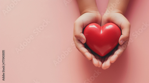 A heart held in both hands  symbolizing love on a pink background