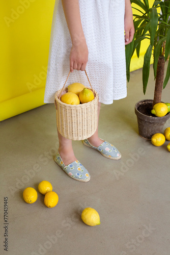 lemons in a straw basket on a yellow background