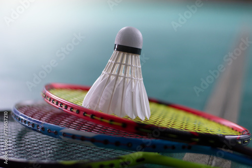 Canvastavla Cream white badminton shuttlecock and racket with neon light shading on green floor in indoor badminton court, blurred badminton court background, copy space