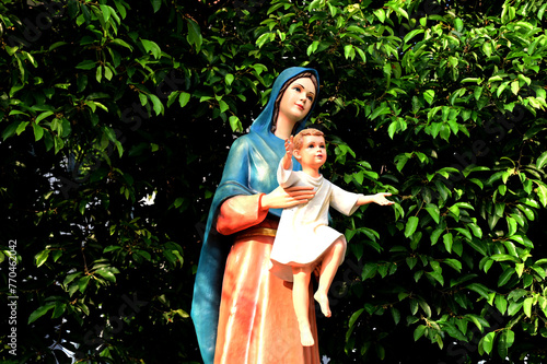 Closeup of Statue of Our lady virgin Mary with Child Jesus located in front of the catholic church with natural background, Thailand. selective focus.