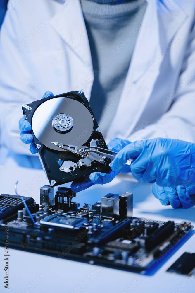 Obraz premium Technician repairing inside of hard disk drive by screwdriver. the concept of data, hardware, technician and technology. computer hardware, upgrade .