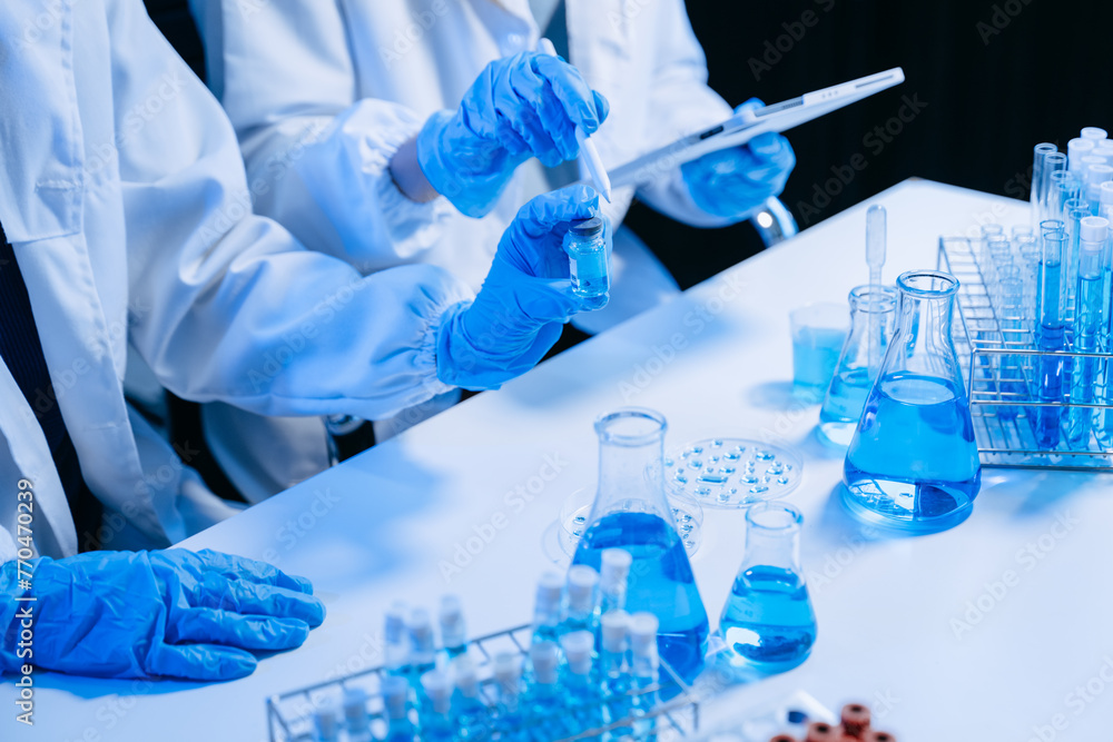 Two Scientist mixing chemical liquids in the chemistry lab. Researcher working in the chemical laboratory Two Scientist mixing chemical liquids in the chemistry lab. Researcher working in the chemical laboratory