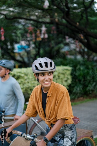 A young woman riding a bike looking up.