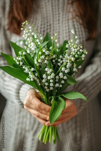 Lilies of the valley in the hands of a woman,  photo