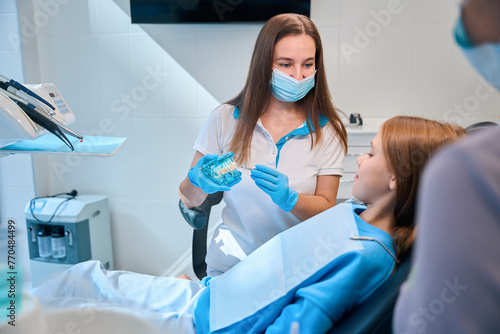 Girl having a consultation with dental hygienist in modern clinic