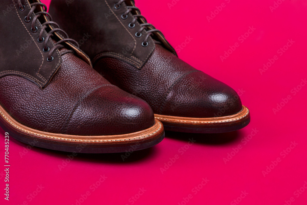 Closeup of Toes of Brown Leather Mens Shoes Over Burgundy Background.