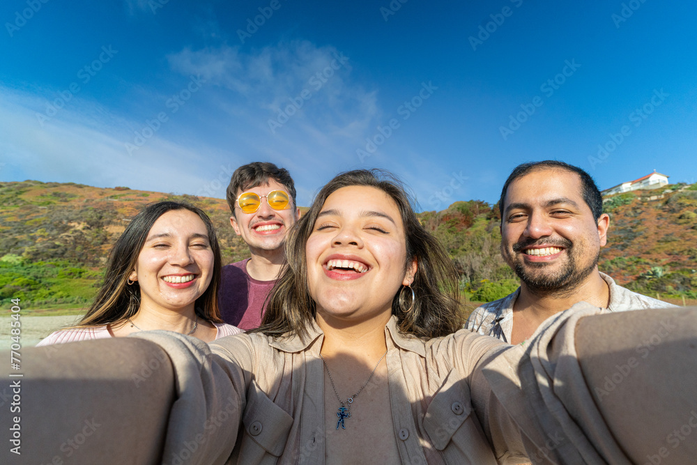 Group of Latino friends taking a selfie while enjoying a sunny day at the beach Group of Latino friends taking a selfie while enjoying a sunny day at the beach