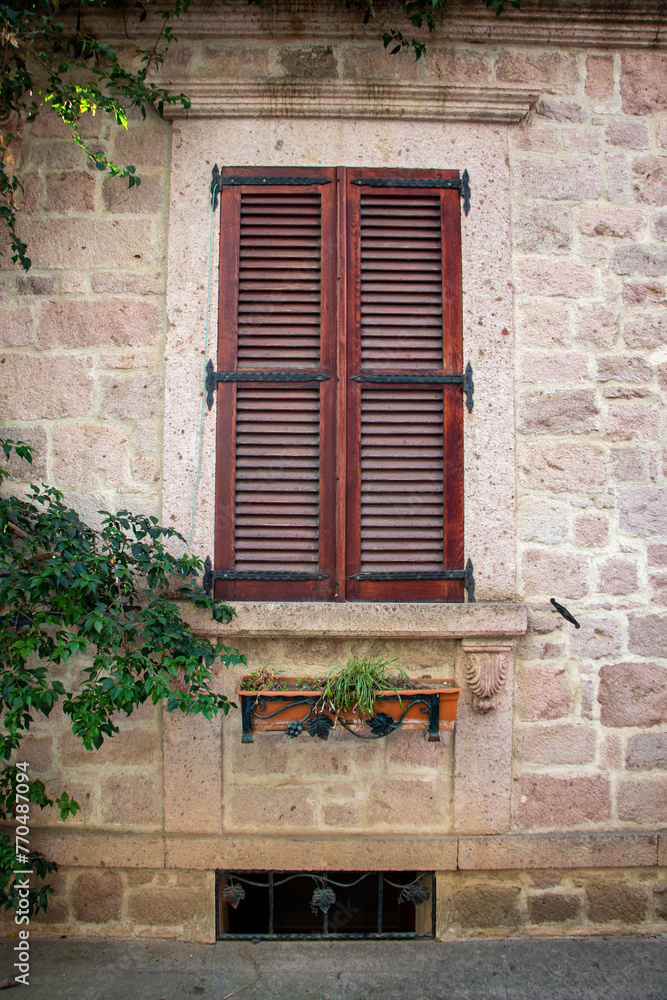 Vintage window with shutters on the wall of an old house..window in Cunda Turkey old construction and wood the historical