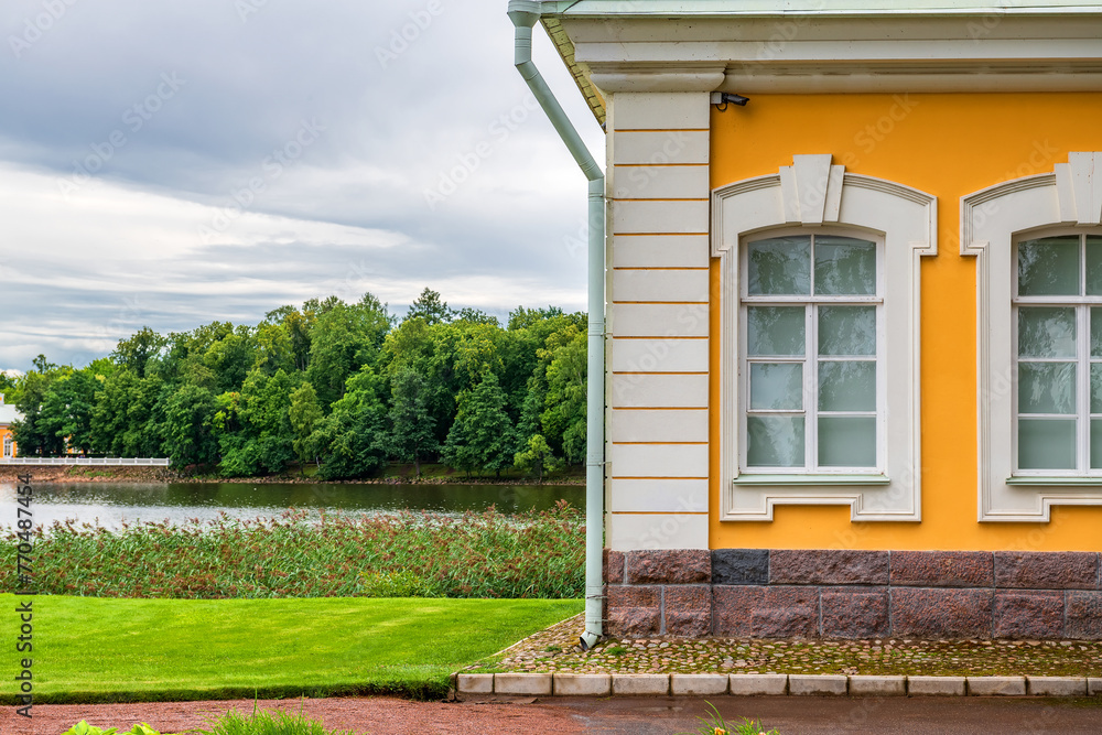Part of the yellow baroque house against the sky, forest and Gulf of Finland. St. Petersburg.