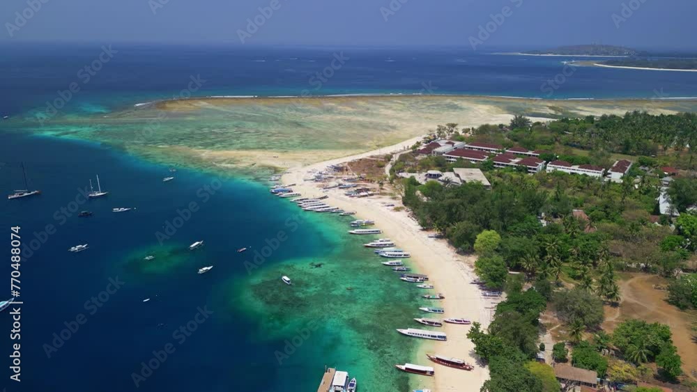 Drone view of wooden boats and a busy port next to a coral reef on a tropical island Drone view of wooden boats and a busy port next to a coral reef on a tropical island