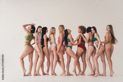 Studio full length no retouch photo shiny adorable ladies dressed lingerie loving themselves embracing isolated beige color wall background