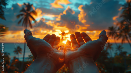 Open hands reaching towards tropical sunset