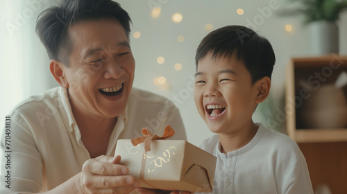 Son surprising Asian father with a gift, priceless joy. Happy Father's day