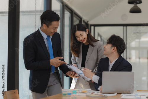Принти на полотні A group of employees happily work together in the office while discussing work that was completed on time as ordered by their boss, A group of entrepreneurs had fun working together