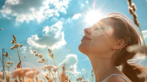 A woman with her eyes closed smiles at the sun	
