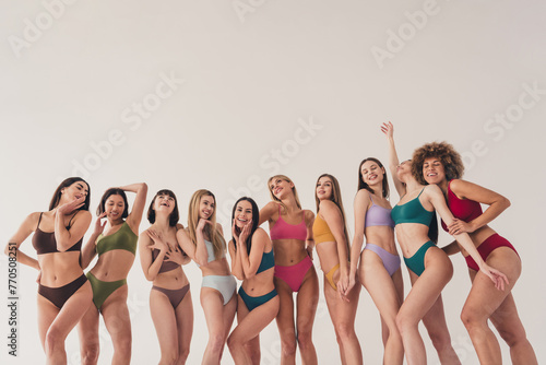 Photo of ten girls lesbians different bodies and imperfections satisfied posing in underwear at white studio background