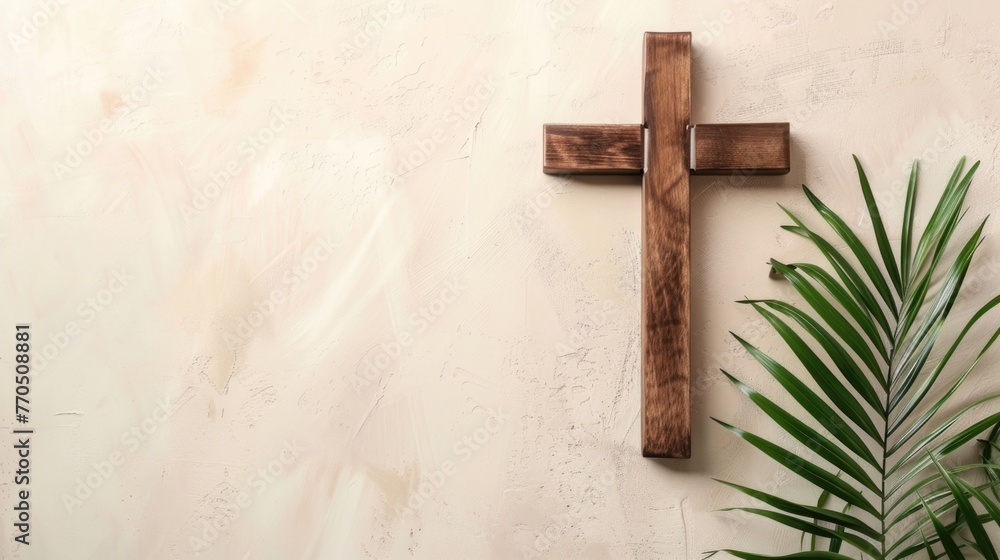 Wooden cross with green palm leaf on textured background.