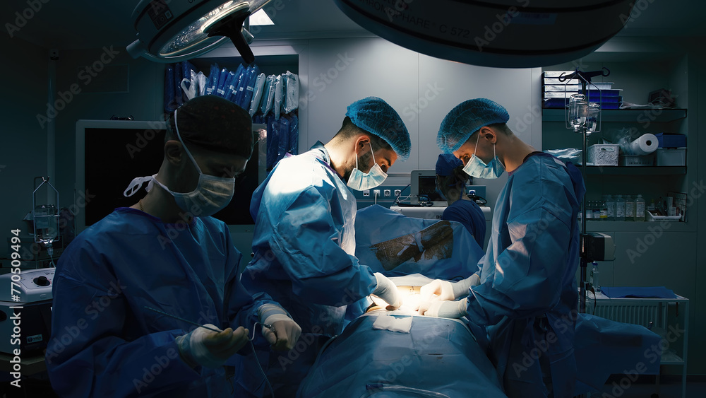 Close-up of surgeons in protective clothing in a modern operating room. Healthcare, surgery and cosmetic surgery concept. - obrazy, fototapety, plakaty 