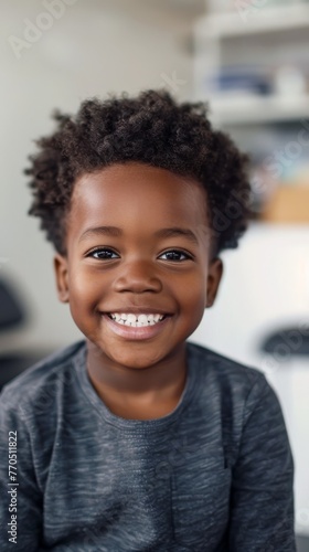 A happy young African American boy sitting in the waiting room of a Doctor or Dentist.