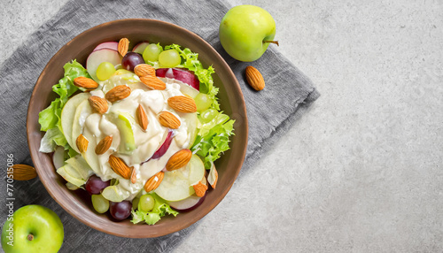 salad bowl. top view of salad with apples, grapes, lettuce, almonds, and mayonnaise dressing with copy space