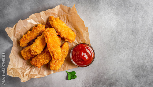 top view shot of Crispy chicken tenders strips with Ketchup on concrete table with copy space photo