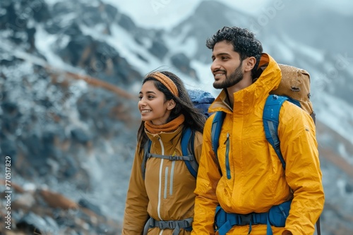 A joyful couple in vibrant jackets hikes in the mountains, tranquil beauty of snow-covered peaks
