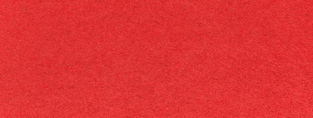 Texture of old bright red color paper background, macro. Structure of a vintage craft scarlet cardboard.