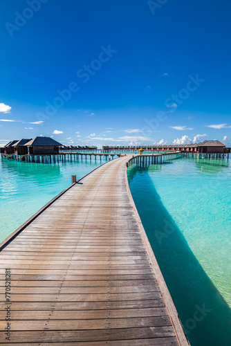 Maldives water villas paradise background. Tropical landscape, seascape with long pier, water villas, amazing sea sky and lagoon beach, tropical nature. Exotic tourism destination, summer vacation © icemanphotos