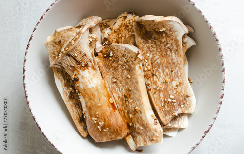 Eryngii mushroom in a white bowl with a marinade of soy sauce, garlic and chili paste. The process of cooking Gochujang King Oyster Mushrooms. Traditional Korean cuisine. Top view.