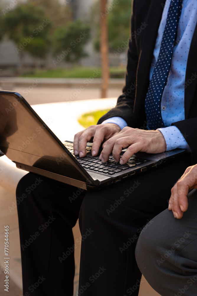  Business on the move: Businessman working on his laptop on the street. Man Hands Type On His Laptop Outdoors - obrazy, fototapety, plakaty 
