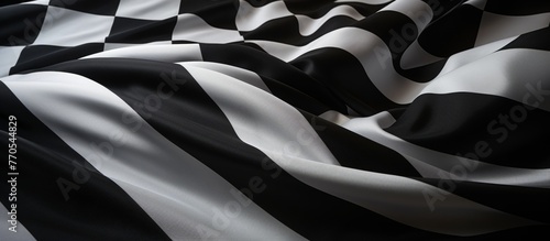 A detailed closeup shot of a monochrome checkered flag fluttering in the wind, showcasing the bold pattern in black and white