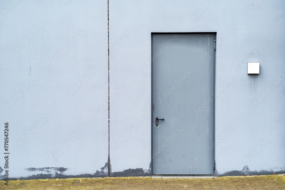gray metal door in white house wall