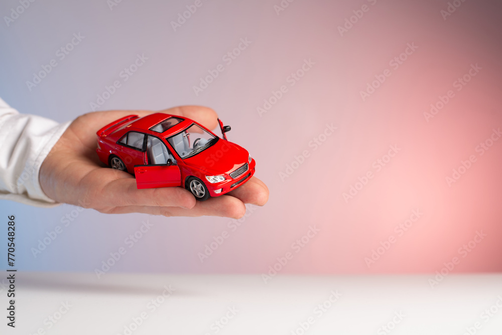 Red toy car in man hand. Sale car - obrazy, fototapety, plakaty 