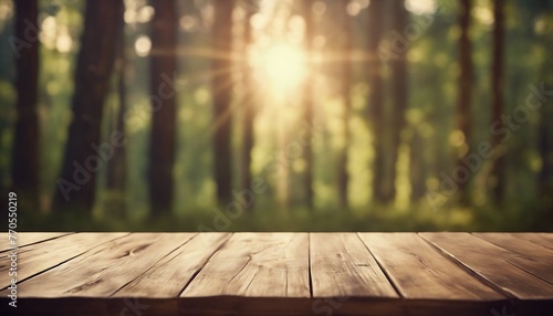 An empty wooden table sits before a blurred forest backdrop, illuminated by sun rays and bokeh lights.