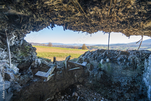 View from destroyed bunker window to the meadow and hills. Protruding rusty reinforcing wires.Poland, Wyrwidab bunker, Wegierska Gorka.