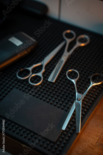 Scissor and clipper in barbeshop on dark rubber background